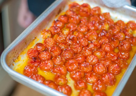 Foto de Tomates rojos cereza cocidos en una bandeja para hornear directamente desde el horno - Imagen libre de derechos