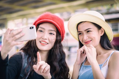 Téléchargez les photos : Asiatiques femmes voyageur ont jouer un téléphone mobile et parler selfie - en image libre de droit