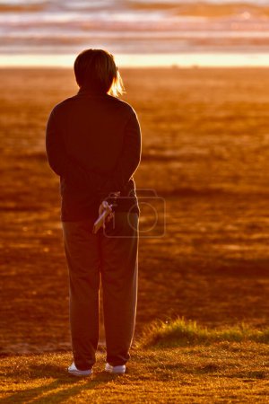 Photo for A beautiful beach, popular among tourists and locals alike. An unidentified person enjoying sunset on a beach. - Royalty Free Image