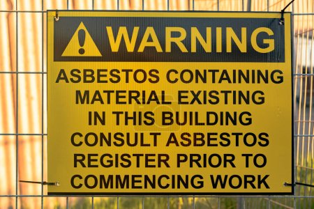 "Asbestos warning sign on background, close up
