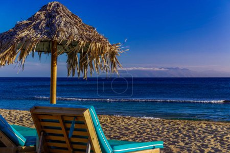 Téléchargez les photos : Chaise de plage et parasol près d'une plage de sable vide - en image libre de droit
