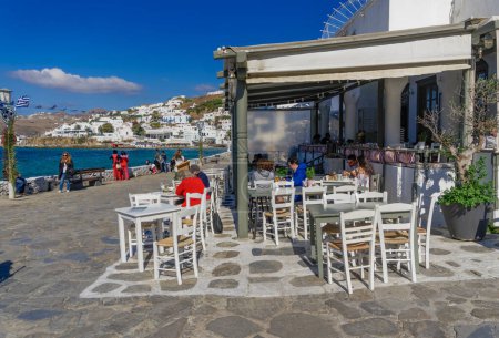 Téléchargez les photos : "Mykonos, Grèce La foule au restaurant de restauration rapide de style taverne." - en image libre de droit