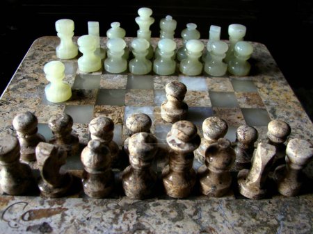 Photo for Closeup of a wooden Chessboard. Chess is a two-player strategy board game played on a checkered board with 64 squares arranged in an 88 grid, believed to be derived from the Indian game Chaturanga - Royalty Free Image