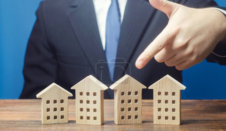Photo for A man chooses an apartment house among many propositions options in the real estate market. Housing solution. Facilities and infrastructure. Investments. Realtor services to find suitable options. - Royalty Free Image