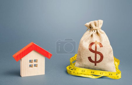 Téléchargez les photos : "Une maison et un sac à billets. Évaluation immobilière. Achat et vente, juste prix. Calcul des dépenses d'achat, de construction et de réparation. Entretien des bâtiments. Prêt hypothécaire" - en image libre de droit