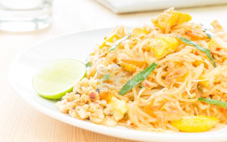 Téléchargez les photos : Nouille thaïlandaise ou thaïlandaise frite sur table en bois - en image libre de droit