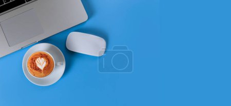 Téléchargez les photos : Vue du dessus de l'ordinateur portable, smartphone, café sur fond bleu - en image libre de droit