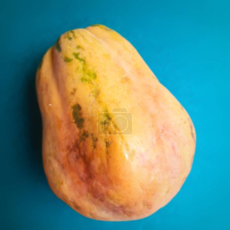 Photo for "Yellow color fresh papaya kept in blue color background and rich in fibre Vitamin C and antioxidants Boosts your immunity" - Royalty Free Image