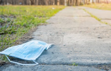 Photo for An infected used medical mask lies on the footpath - Royalty Free Image