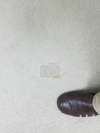Foto de Zapato marrón en alfombra blanca manchada sucia - Imagen libre de derechos