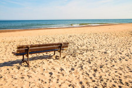 Photo for Bench on a lonesome beach of the Baltic Sea with blue sky - Royalty Free Image