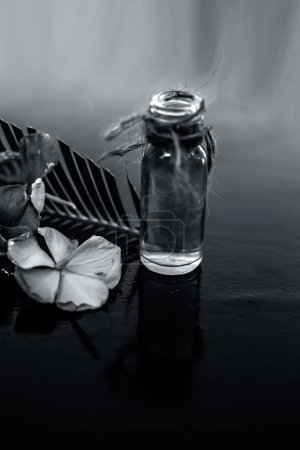 Foto de "Esencia o concentración herbal y floral hecha de Rosmarinus officinalis también conocida como flor de romero en una botella de vidrio en la superficie de madera
." - Imagen libre de derechos