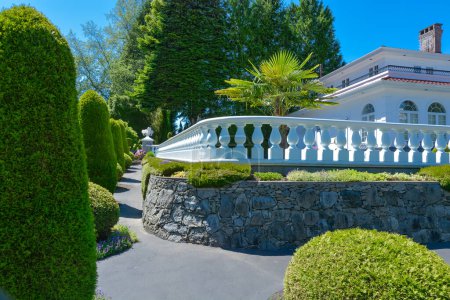 Téléchargez les photos : Maison résidentielle de luxe clôturée avec balustrade blanche construite sur terrasse - en image libre de droit