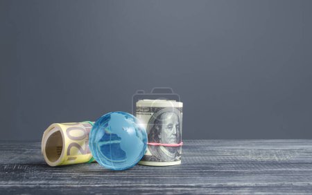 Photo for Money bundle rolls world currencies and a blue glass globe. Capital investment, savings. Profit income, dividends payouts. Crowdfunding startups investing. Banking service, budget monetary policy - Royalty Free Image