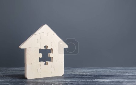 Téléchargez les photos : "Maison de puzzle avec une pièce manquante. Achat ou construction confortable maison de rêve. Prêt hypothécaire achat immobilier. Arrangement locaux réparation. Disponibilité et bon marché. Terminer le bâtiment" - en image libre de droit