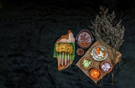 Foto de "Carne de cerdo satay comer con su salsa de maní y encurtidos que son c" - Imagen libre de derechos