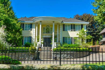 Téléchargez les photos : Maison résidentielle de luxe avec clôture métallique en face en banlieue de Vancouver - en image libre de droit