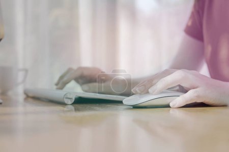 Foto de "manos de una mujer usando el ratón inalámbrico en el escritorio" - Imagen libre de derechos