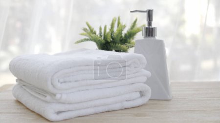 Téléchargez les photos : Bouteille de savon liquide et serviettes blanches Mettre sur la table dans la salle de bain - en image libre de droit
