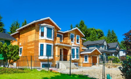 Téléchargez les photos : Maison résidentielle neuve en construction sur fond de ciel bleu - en image libre de droit