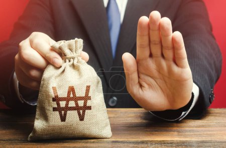 Photo for Businessman refuses to give south korean won money bag. Stop financing projects and reforms, crisis financial difficulties. Loan refusal, bad credit history. Asset freeze. Payment refund. Deception - Royalty Free Image