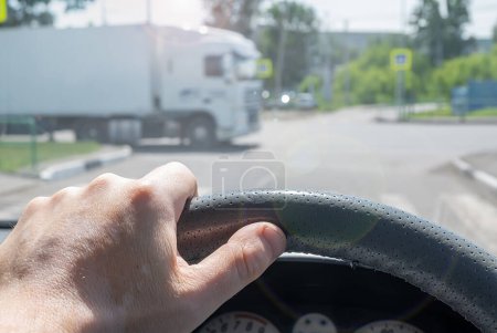 Téléchargez les photos : Vue de la main du conducteur au volant d'une voiture sur une route - en image libre de droit