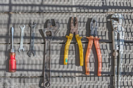 Téléchargez les photos : Grand ensemble d'outils ménagers, pinces et clés sur une table en bois - en image libre de droit