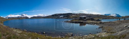Téléchargez les photos : Large vue panoramique depuis Sognefjellshytta avec glacier bleu Lac Fantesteinsvatnet le long de la route panoramique nationale Sognefjellet entre Skjolden dans l'ouest de la Norvège. Automne ciel bleu
. - en image libre de droit