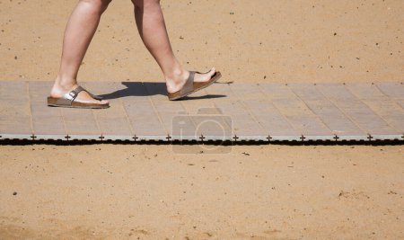 Téléchargez les photos : Pieds dans les ardoises d'été sur la piste de sable de plage - en image libre de droit