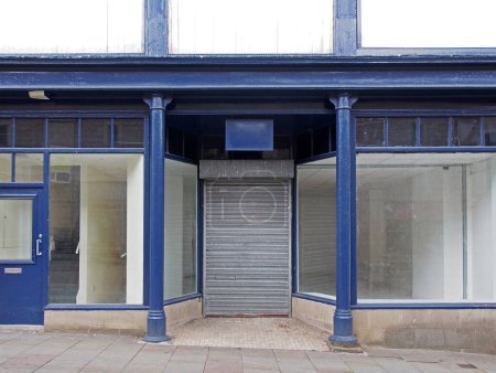 Téléchargez les photos : La façade d'une vieille boutique abandonnée peinte en bleu et blanc avec des fenêtres sales et des volets fermés sur la porte ; - en image libre de droit