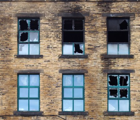 Téléchargez les photos : Fenêtres cassées dans un grand bâtiment industriel brûlé après un incendie - en image libre de droit