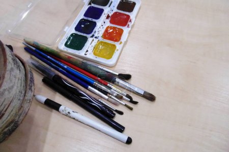 Photo for Watercolor paints and pencils on a white table - Royalty Free Image