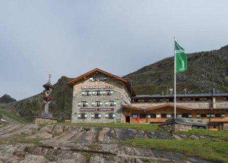 Téléchargez les photos : Stubai Valley, Innsbruck - Land, Tyrol, Autriche, 4 juillet 2020 : Vue de la cabane alpine Dresdner Huette, hôtel de montagne, matin brumeux d'été, arrière-plan ciel clair - en image libre de droit
