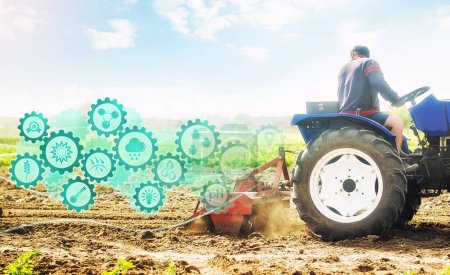 Téléchargez les photos : Agriculteur sur un tracteur cultive un champ agricole et l'innovation technologique engrenages hologramme. Science de l'agronomie. Démarrages agricoles et agricoles. Améliorer l'efficacité. Fraisage, émiettage et mélange du sol - en image libre de droit