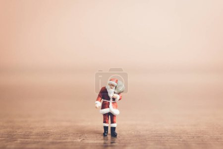 Photo for Miniature people Santa Claus carrying bag , Christmas celebration - Royalty Free Image