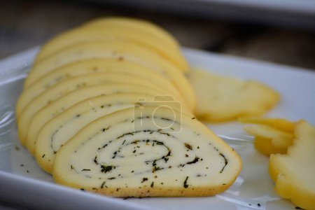 Téléchargez les photos : Tranches de fromage épicé artisanal sur une assiette - en image libre de droit