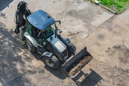 Téléchargez les photos : Tracteur avec godet pour travaux d'excavation pendant la construction de la route - en image libre de droit