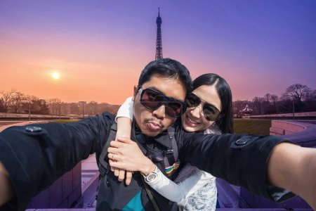 Téléchargez les photos : Jeune Couple Touristes selfie avec téléphone portable près de la Tour Eiffel - en image libre de droit