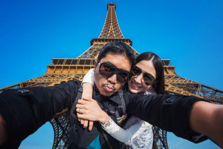 Foto de Joven pareja de turistas selfie con teléfono móvil cerca de la torre Eiffel - Imagen libre de derechos