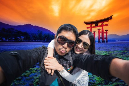 Foto de Joven pareja de turistas selfie con teléfono móvil cerca de la puerta de Tori - Imagen libre de derechos