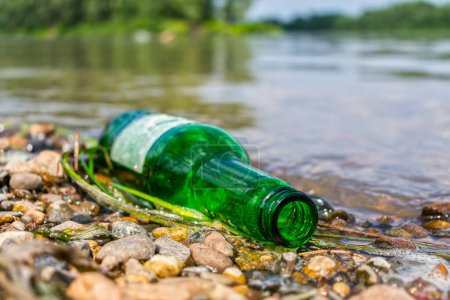 Foto de Una botella de vidrio arrojada a tierra contamina el medio ambiente y daña la naturaleza - Imagen libre de derechos