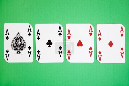 Téléchargez les photos : Quatre as jouant aux cartes sur la surface verte - en image libre de droit