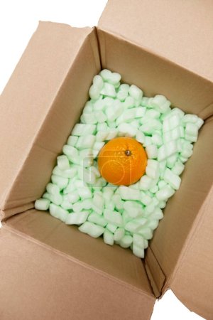 Photo for Open cardboard box with packing peanuts and orange - Royalty Free Image