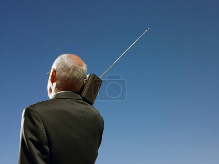Photo for "Businessman with radio on shoulder head and shoulders back view" - Royalty Free Image