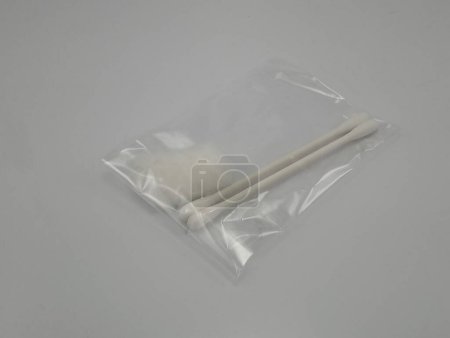Foto de Brotes de algodón blanco en palo colocado en plástico transparente - Imagen libre de derechos