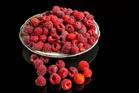 Photo for Fresh raspberries on a plate against a black background - Royalty Free Image