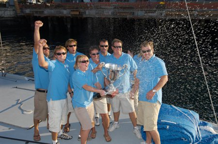 Foto de "Equipo de vela celebrando con trofeo en barco" - Imagen libre de derechos
