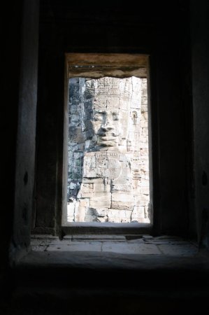 Photo for "Stone Face Sculpture Seen Through Window of Ruins" - Royalty Free Image