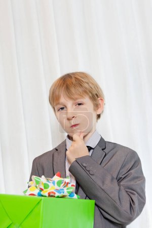 Photo for Portrait of young boy staring with hand on chin - Royalty Free Image