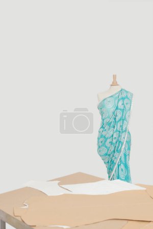 Téléchargez les photos : Sari drapé sur le mannequin du tailleur avec des découpes en carton sur la table - en image libre de droit